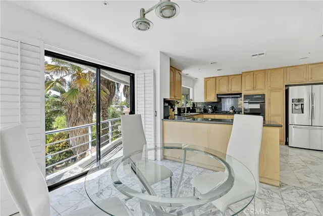 a living room with stainless steel appliances furniture and a large window