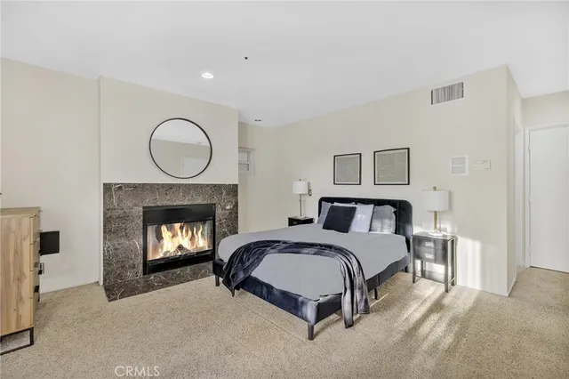 a spacious bedroom with a bed and a fireplace