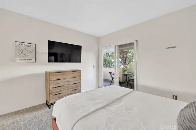 a bedroom with a bed and a potted plant on dresser