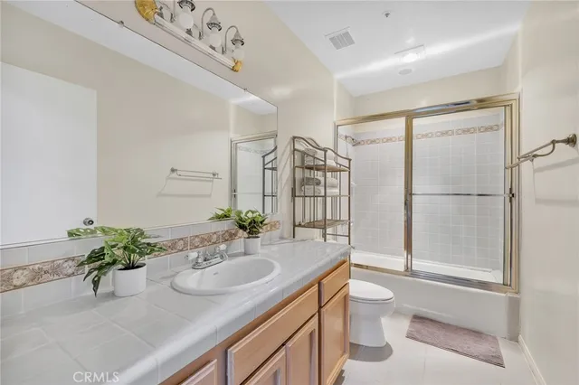 a bedroom with a bed a mirror and a large window with outer view