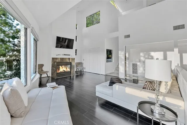 a living room with furniture fireplace and a large window