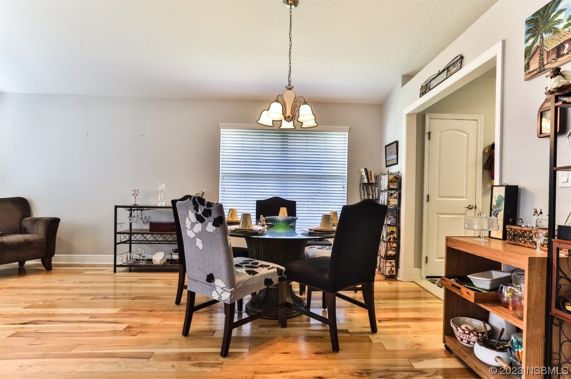 811 Star Reef Lane Edgewater, FL 32132 - Photo 11 of 35 a dining room with furniture a chandelier and wooden floor