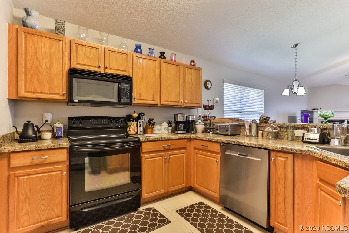 811 Star Reef Lane Edgewater, FL 32132 - Photo 13 of 35 a kitchen with stainless steel appliances granite countertop a stove a sink dishwasher and a microwave oven with large cabinets