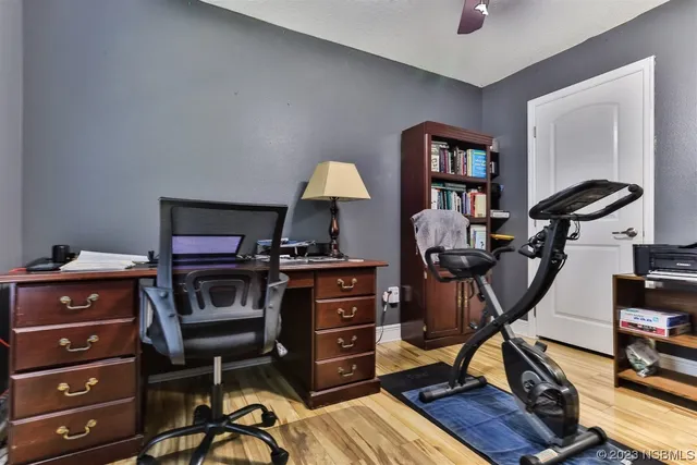 a view of a workspace with furniture and a window