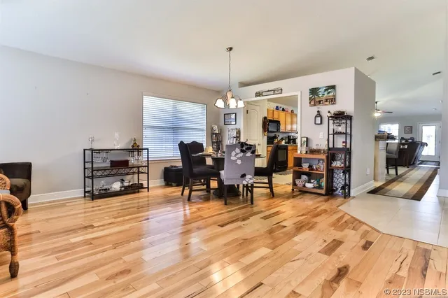 a living room with furniture a dining table and chairs with wooden floor