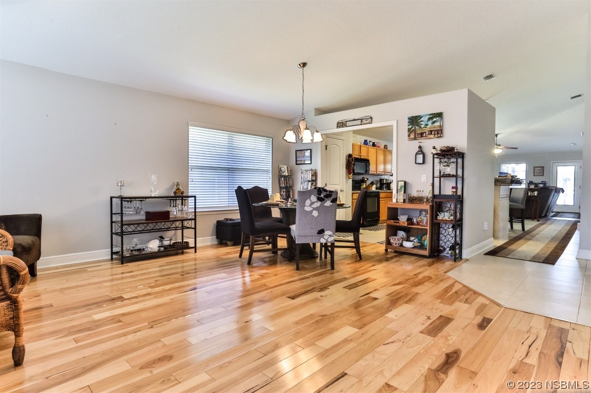 811 Star Reef Lane Edgewater, FL 32132 - Photo 9 of 35 a living room with furniture a dining table and chairs with wooden floor