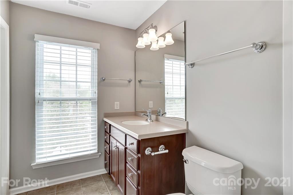 905 Lyndley Drive Fort Mill, SC 29708 - Photo 14 of 28 a bathroom with a sink a toilet a mirror and window