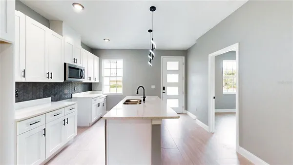 a kitchen with granite countertop a stove a sink dishwasher and a refrigerator with wooden floor