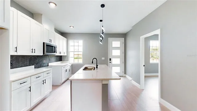 a kitchen with granite countertop a stove a sink dishwasher and a refrigerator with wooden floor