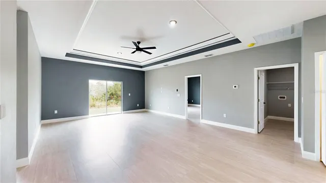 a view of an empty room with window and wooden floor