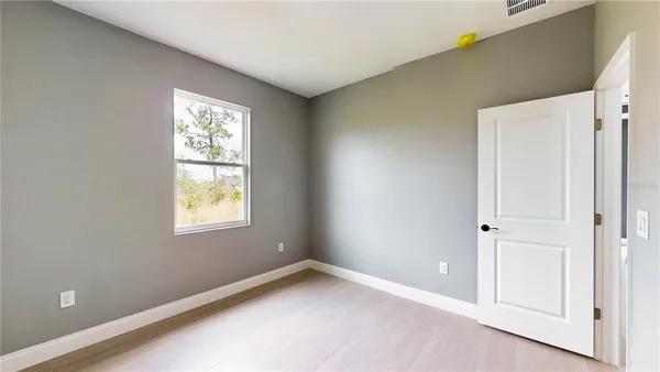 an empty room with windows and closet