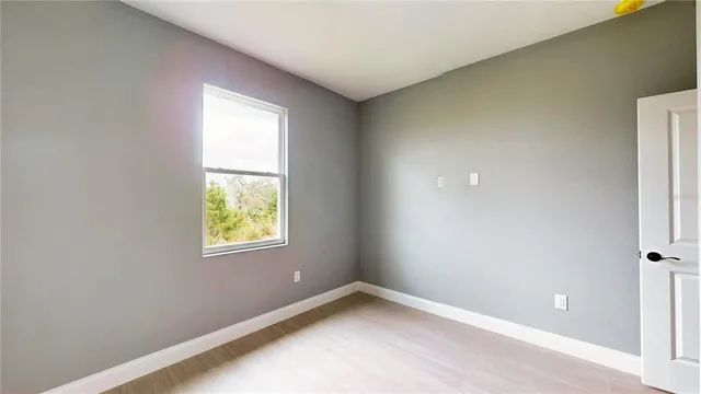 an empty room with wooden floor and closet