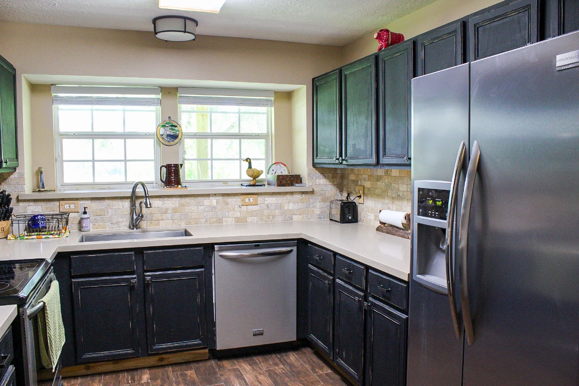1076 West Branding Iron Road Weimar, TX 78962 - Photo 11 of 24 a kitchen with a sink a window and cabinets