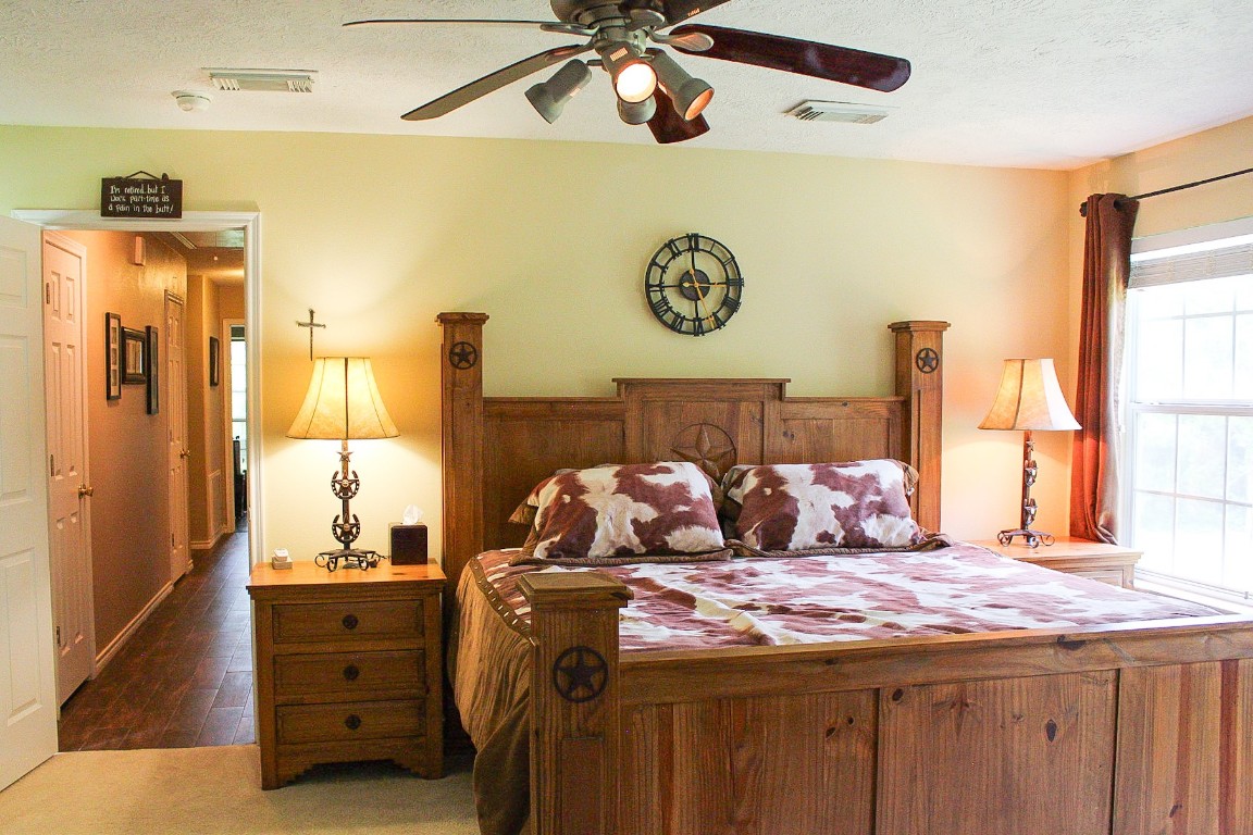1076 West Branding Iron Road Weimar, TX 78962 - Photo 16 of 24 a bedroom with a bed and a chandelier