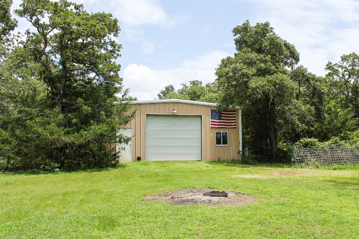 1076 West Branding Iron Road Weimar, TX 78962 - Photo 7 of 24 a backyard of a house with large trees and plants