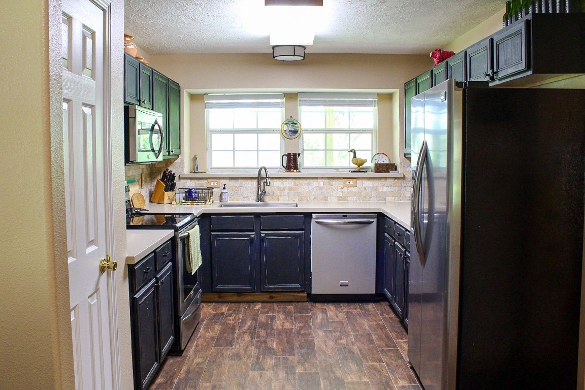 1076 West Branding Iron Road Weimar, TX 78962 - Photo 10 of 24 a kitchen with granite countertop a refrigerator stove and sink