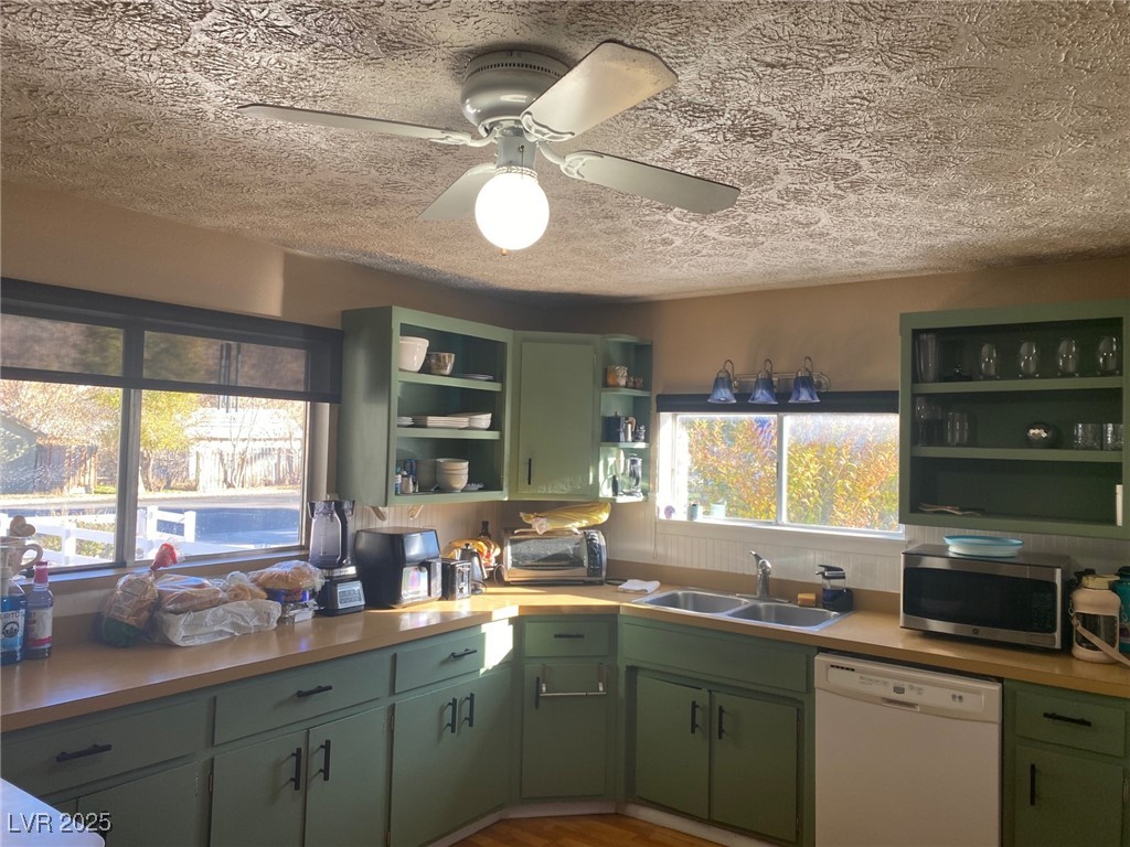 735 Canyon Street Ely, NV 89301 - Photo 5 of 19 Kitchen featuring green cabinetry, open shelves, dishwasher, light countertops, and a textured ceiling