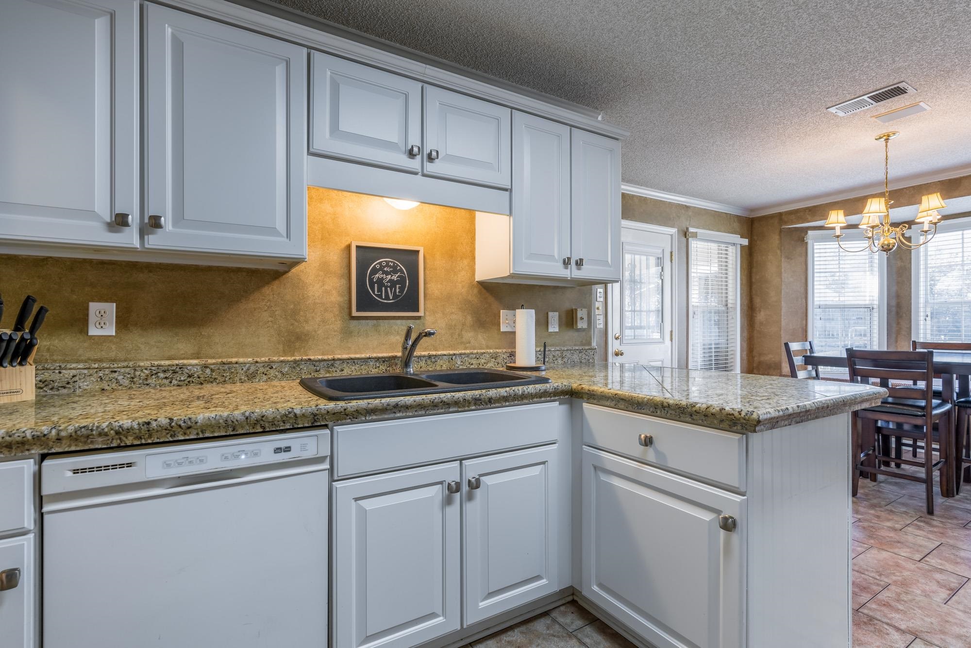 8599 Brer Fox Cove Memphis, TN 38018 - Photo 12 of 25 a kitchen with granite countertop cabinets sink and white appliances