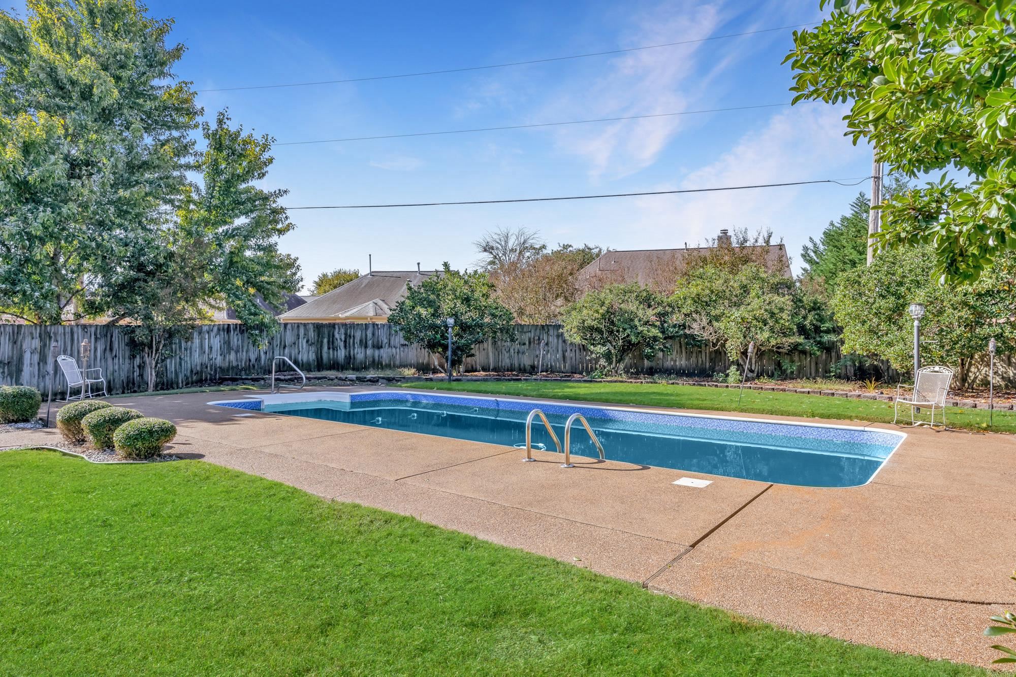 8599 Brer Fox Cove Memphis, TN 38018 - Photo 17 of 25 a view of a swimming pool with a yard and a bench
