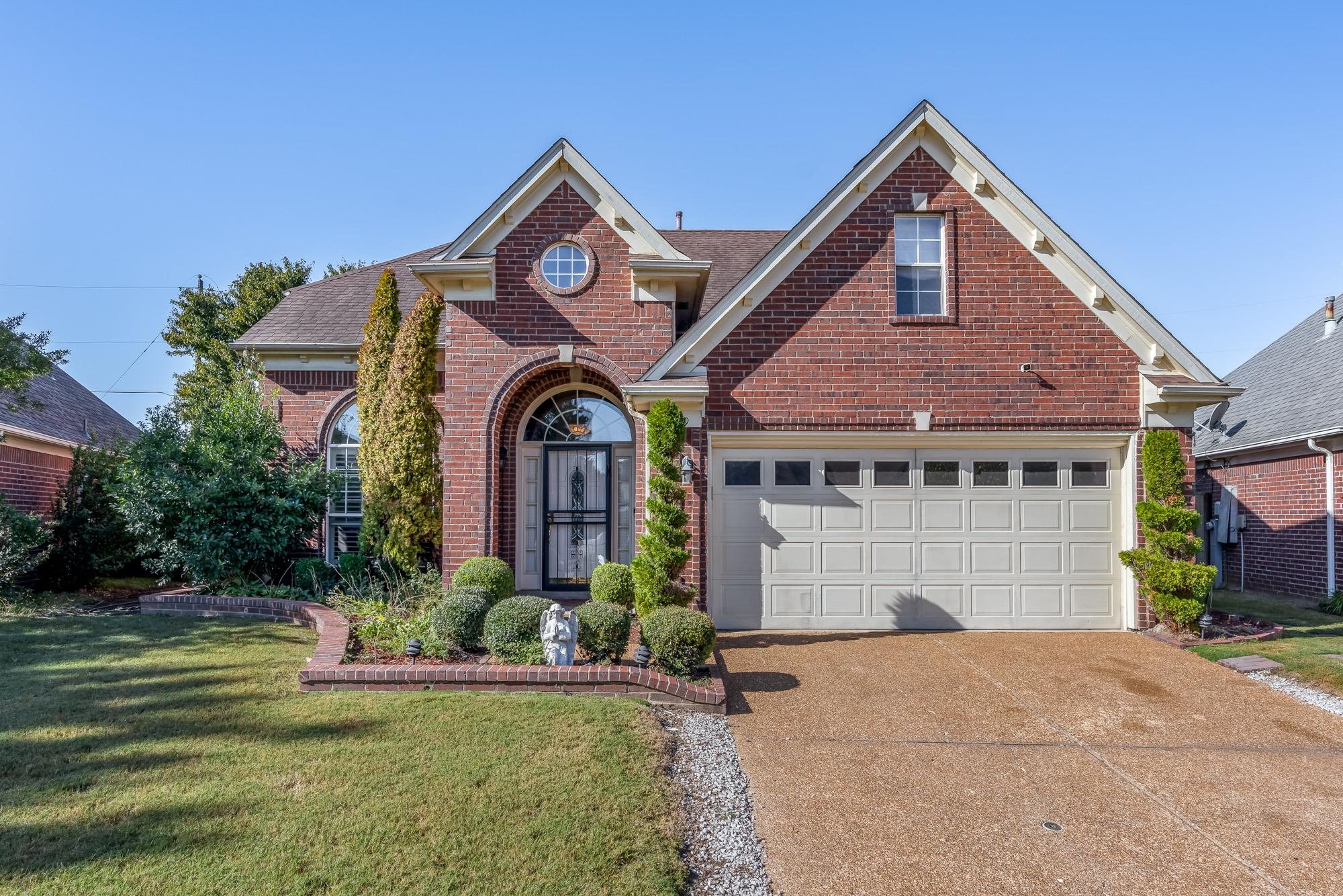 8599 Brer Fox Cove Memphis, TN 38018 - Photo 2 of 25 a front view of a house with a garden