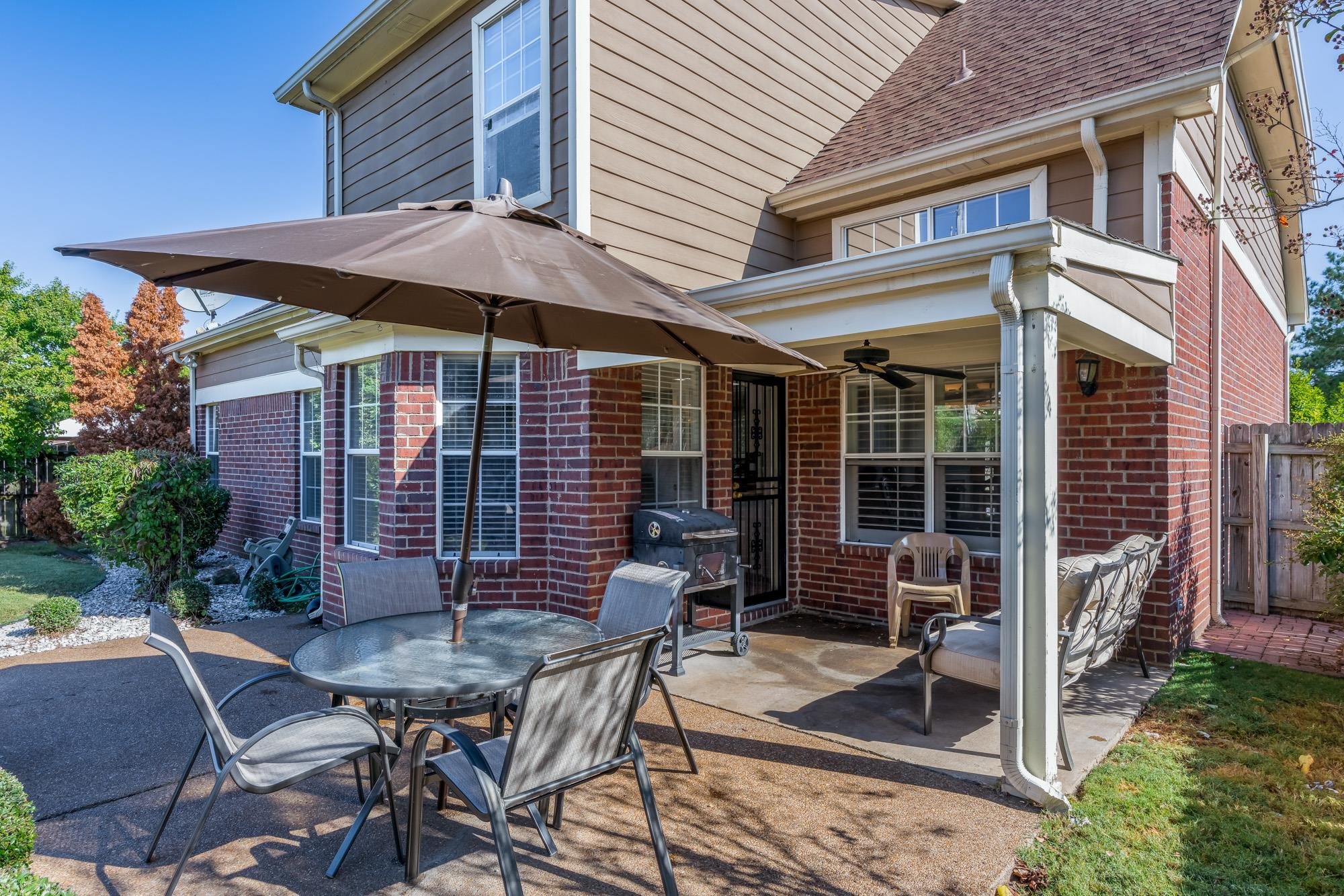 8599 Brer Fox Cove Memphis, TN 38018 - Photo 24 of 25 a view of a patio with table and chairs under an umbrella