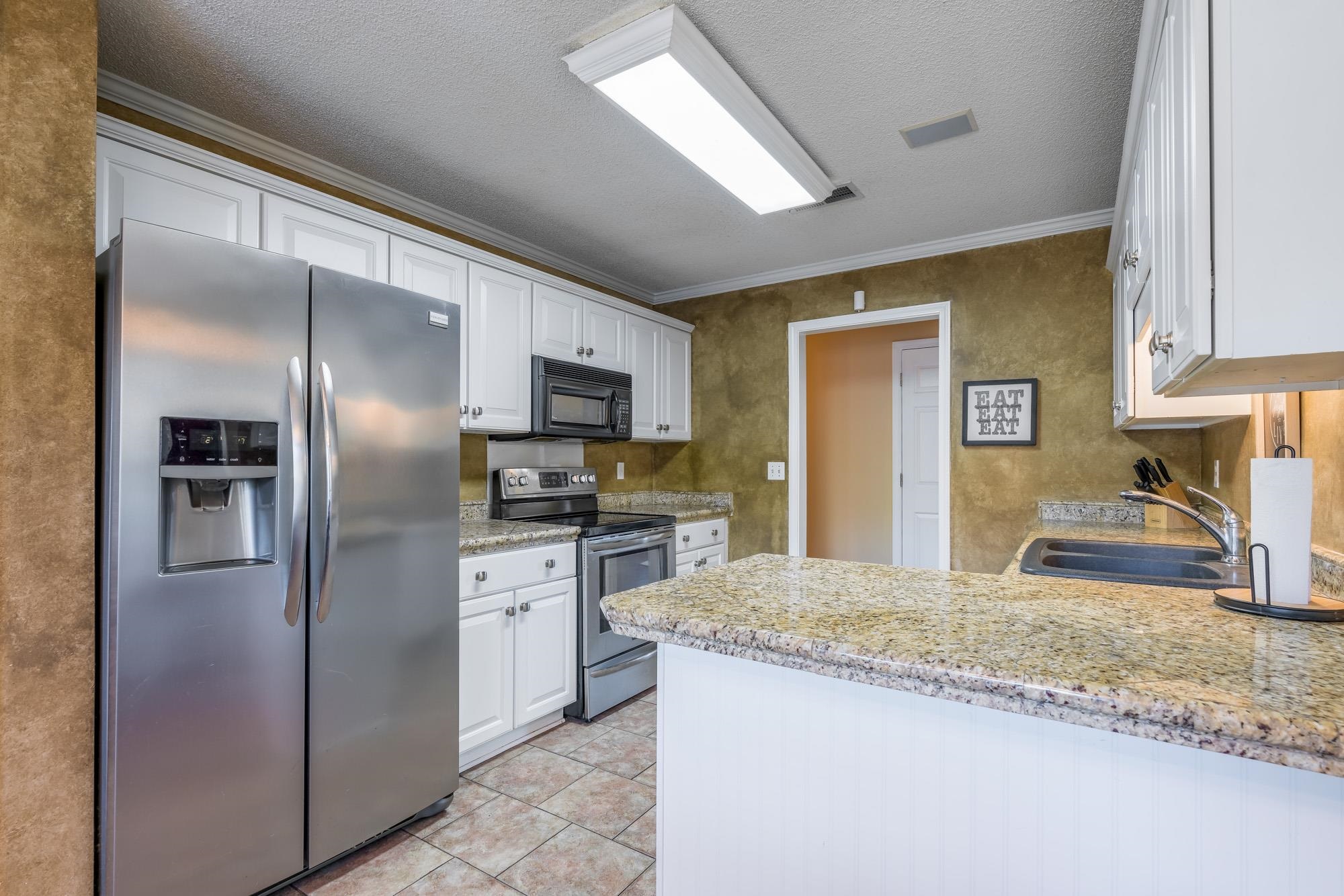8599 Brer Fox Cove Memphis, TN 38018 - Photo 9 of 25 a kitchen with stainless steel appliances granite countertop a refrigerator a stove and a sink