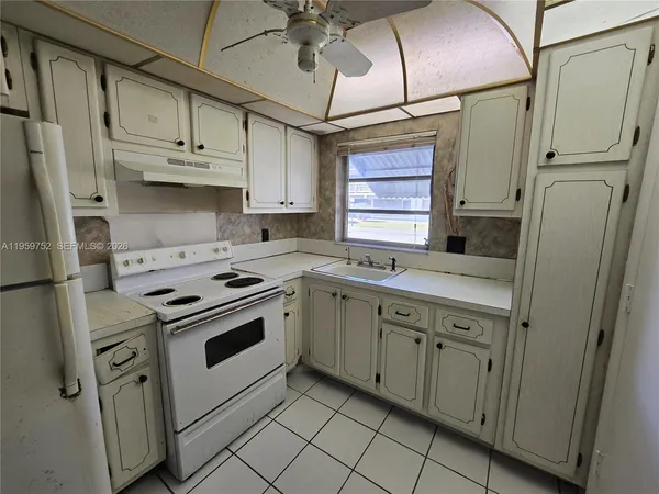 a kitchen with cabinets appliances a sink and a window