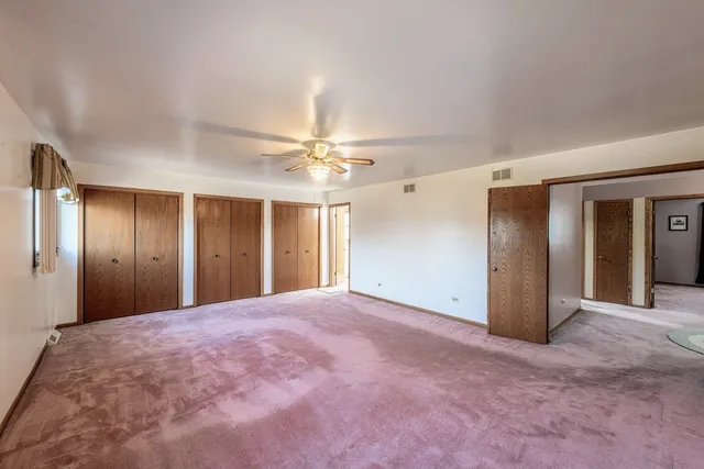 a view of an empty room with a ceiling fan