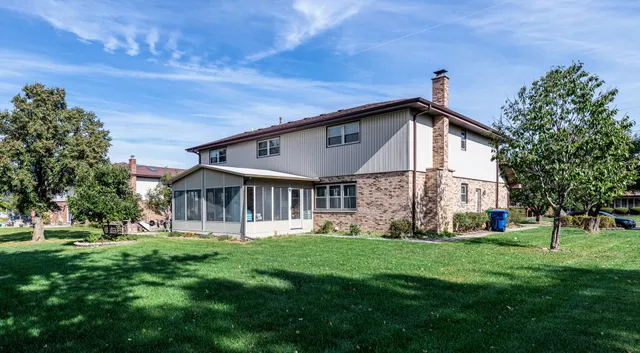 a front view of a house with a yard and trees