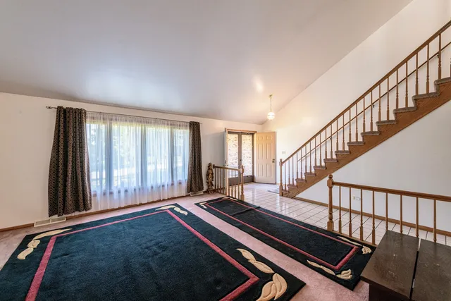 a living room with chairs and a window