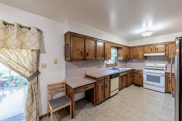 a kitchen with stainless steel appliances granite countertop a stove refrigerator and cabinets