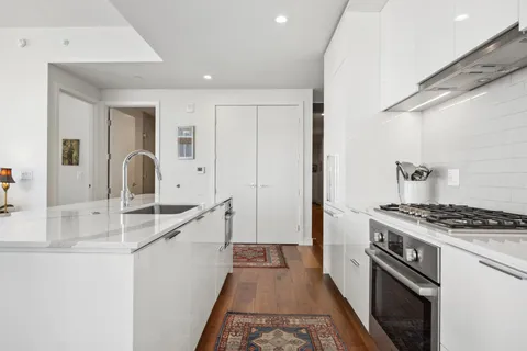 a kitchen with granite countertop a sink stove and refrigerator
