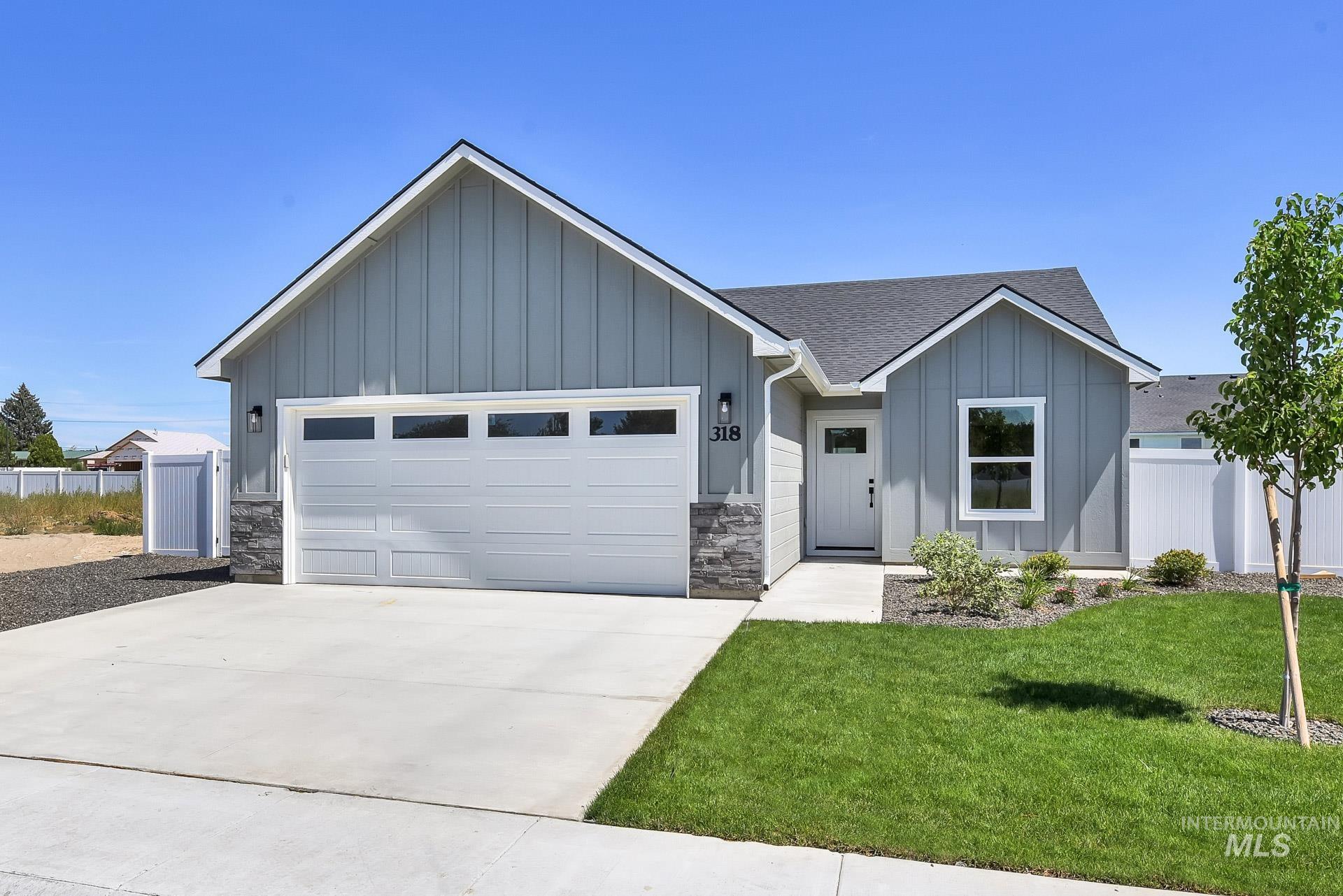 View of front of property featuring board and batten siding, stone siding, a shingled roof, and a garage
