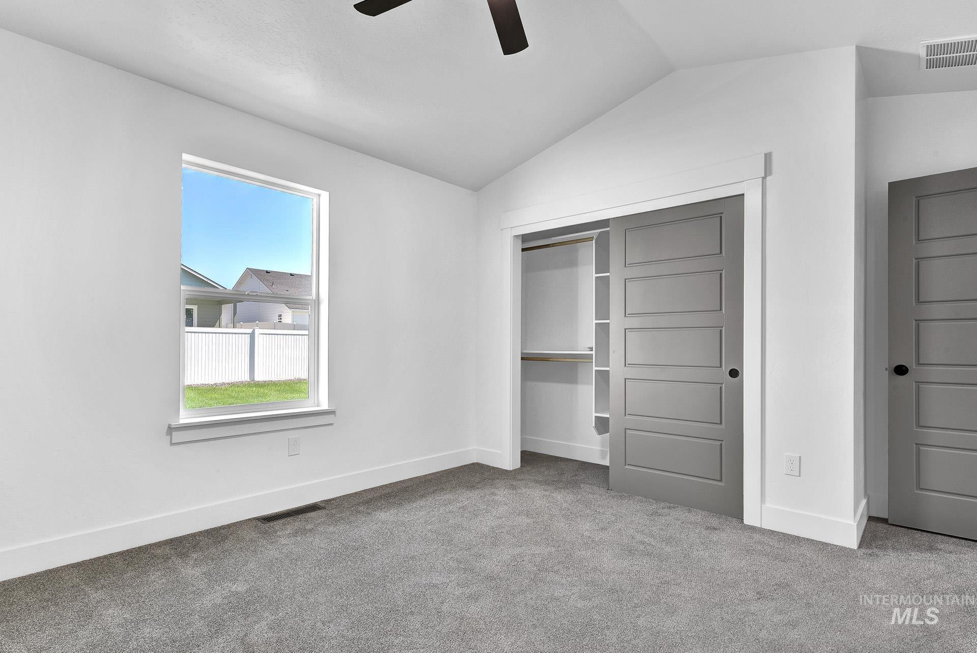 1162 Velvet Loop Wilder, ID 83676 - Photo 16 of 31 Unfurnished bedroom with lofted ceiling, carpet floors, a closet, and a ceiling fan