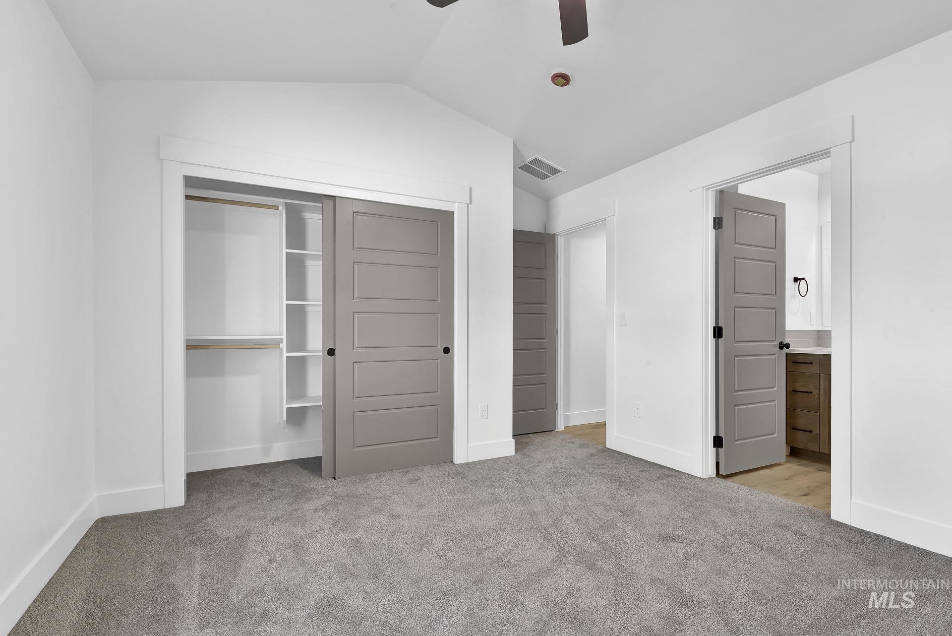 1162 Velvet Loop Wilder, ID 83676 - Photo 17 of 31 Unfurnished bedroom with light colored carpet, a closet, lofted ceiling, a ceiling fan, and ensuite bathroom