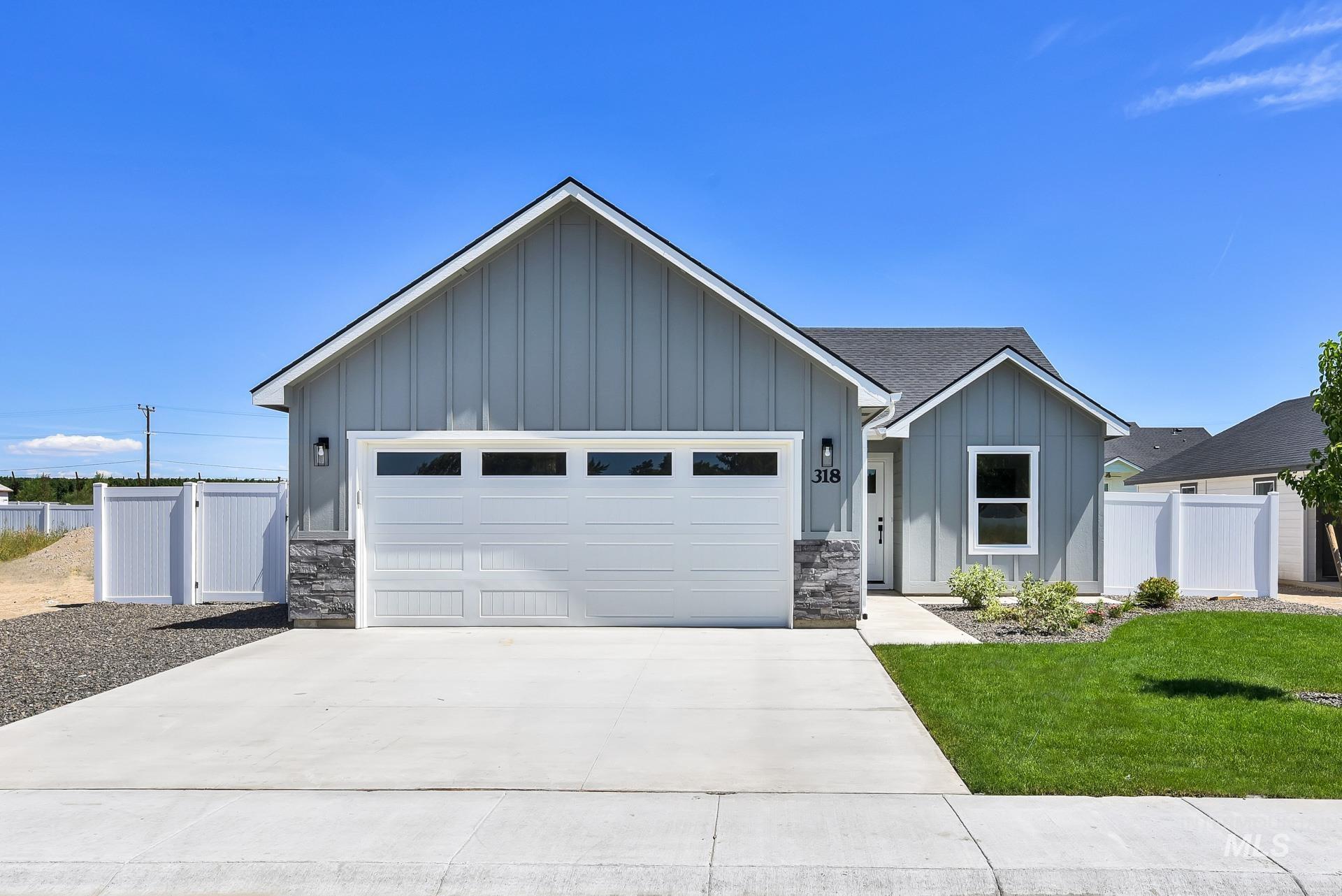 1162 Velvet Loop Wilder, ID 83676 - Photo 2 of 31 View of front facade featuring board and batten siding, stone siding, concrete driveway, a gate, and a garage