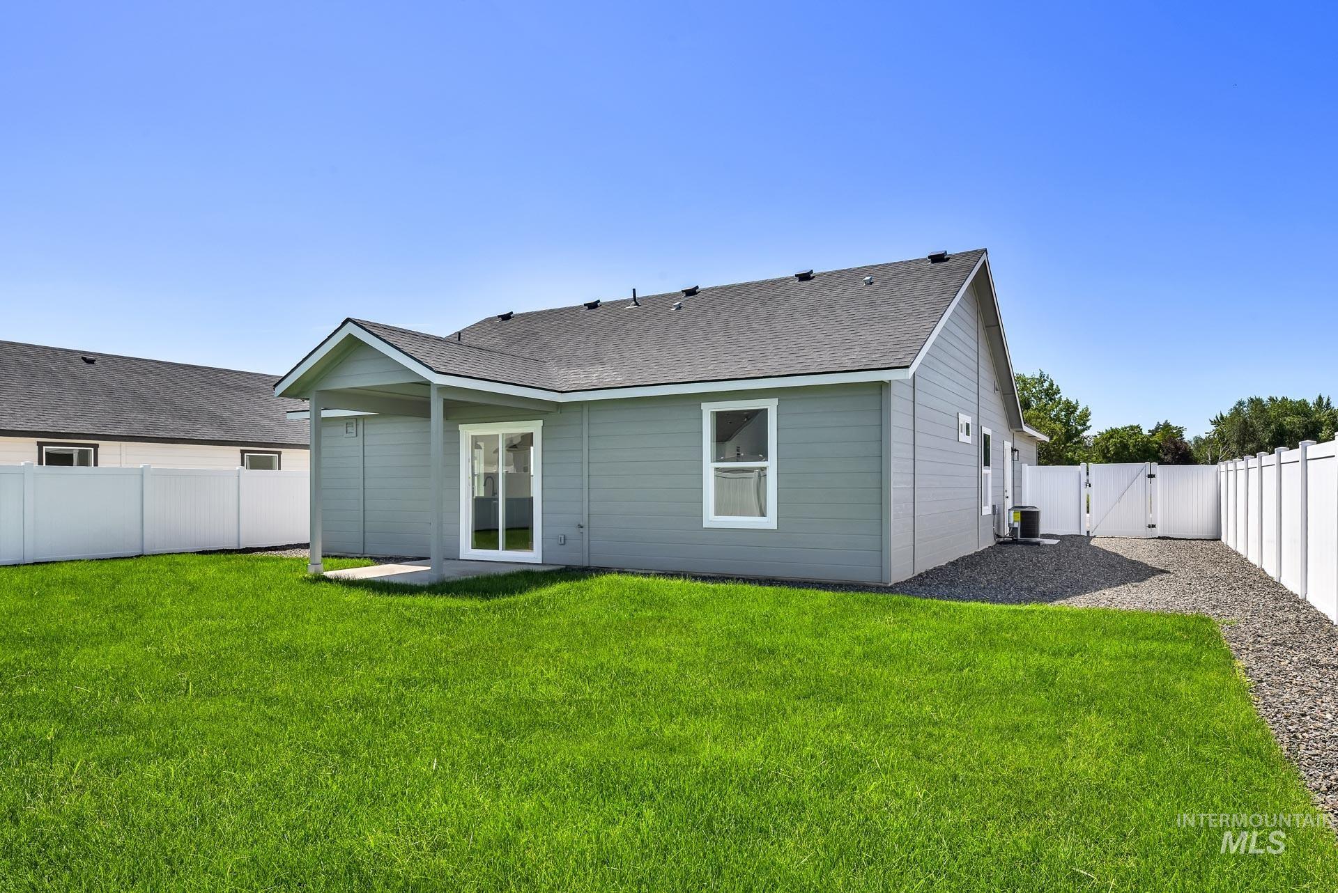 1162 Velvet Loop Wilder, ID 83676 - Photo 30 of 31 Back of house with a gate, a fenced backyard, and roof with shingles