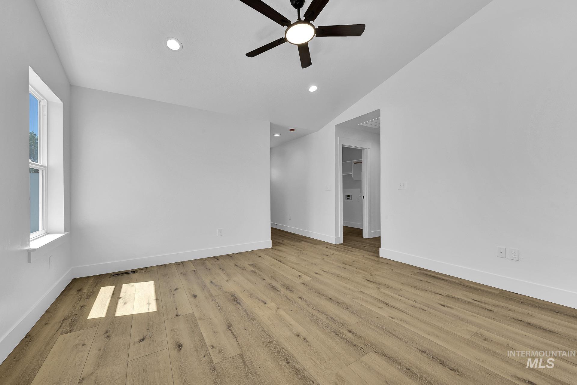 1162 Velvet Loop Wilder, ID 83676 - Photo 7 of 31 Empty room with light wood-style floors, vaulted ceiling, ceiling fan, and recessed lighting
