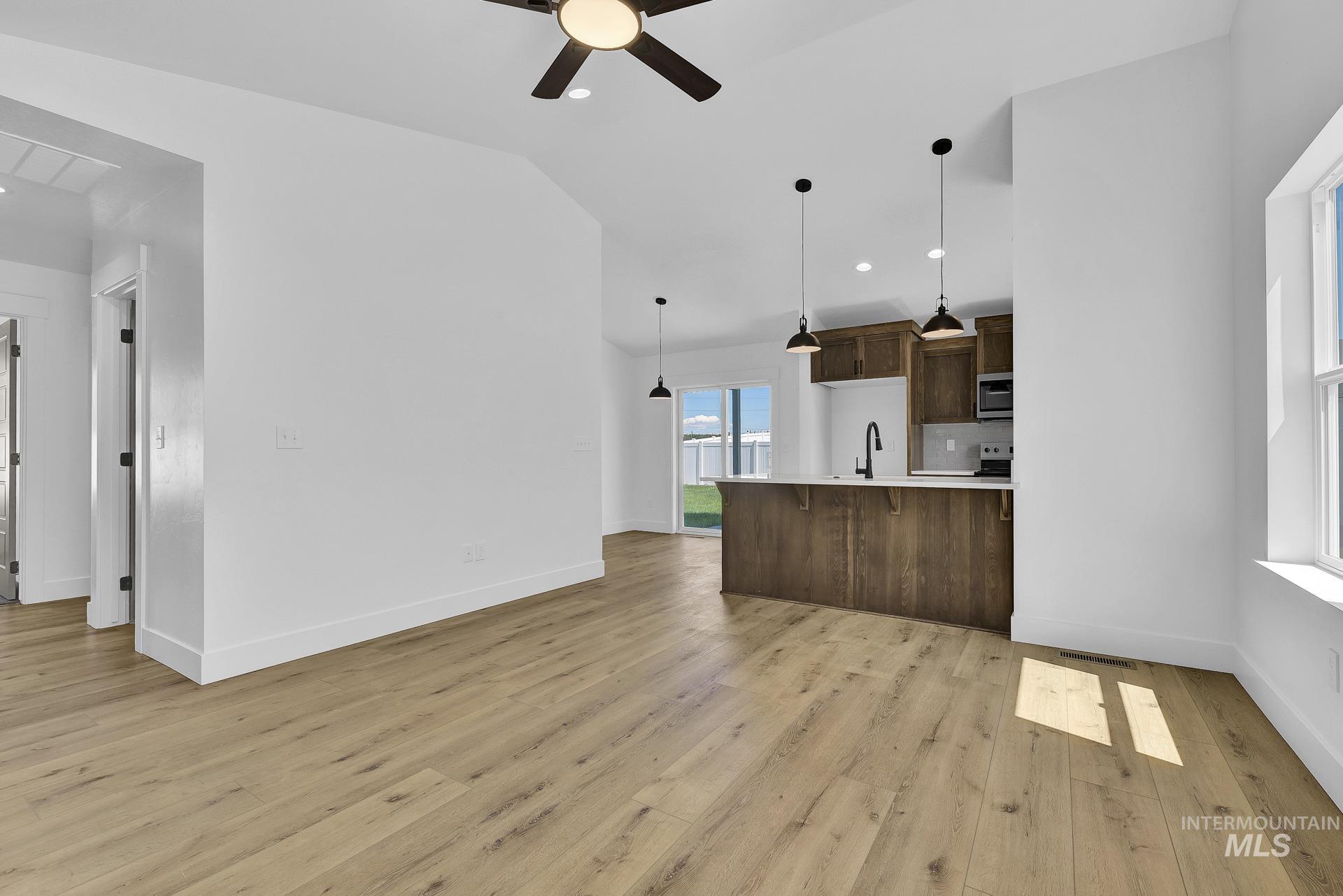 1162 Velvet Loop Wilder, ID 83676 - Photo 31 of 31 Kitchen with open floor plan, dark brown cabinetry, decorative light fixtures, vaulted ceiling, and a ceiling fan