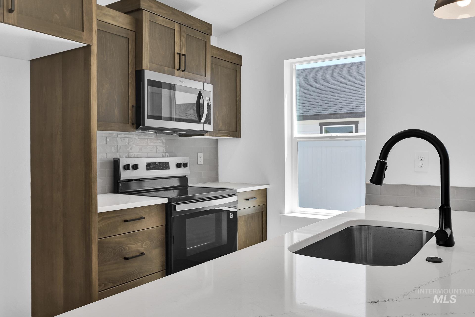 1162 Velvet Loop Wilder, ID 83676 - Photo 9 of 31 Kitchen featuring appliances with stainless steel finishes, backsplash, and light stone countertops