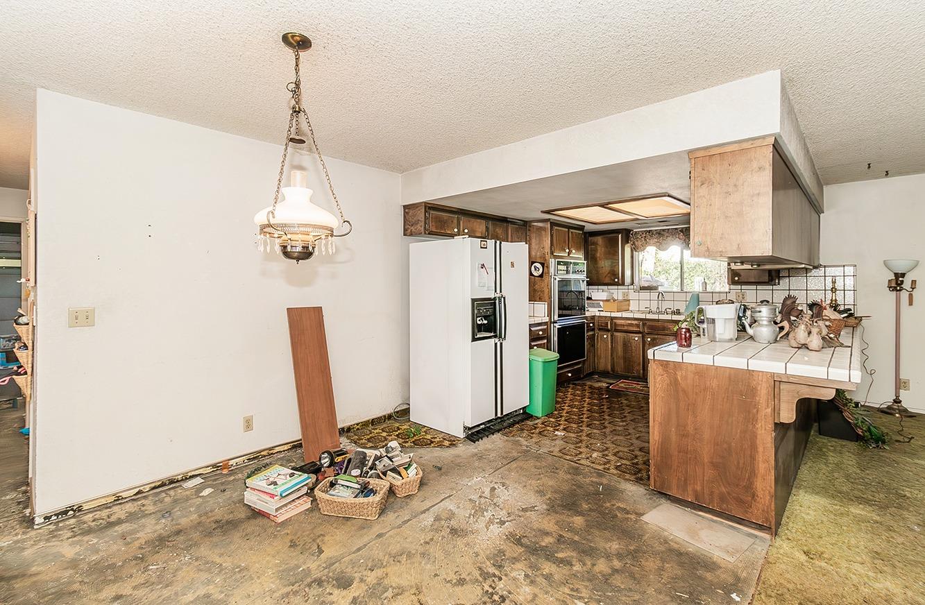 2501 Ashcroft Avenue Clovis, CA 93611 - Photo 8 of 24 a view of a kitchen with kitchen island a stove a refrigerator and a view of living room