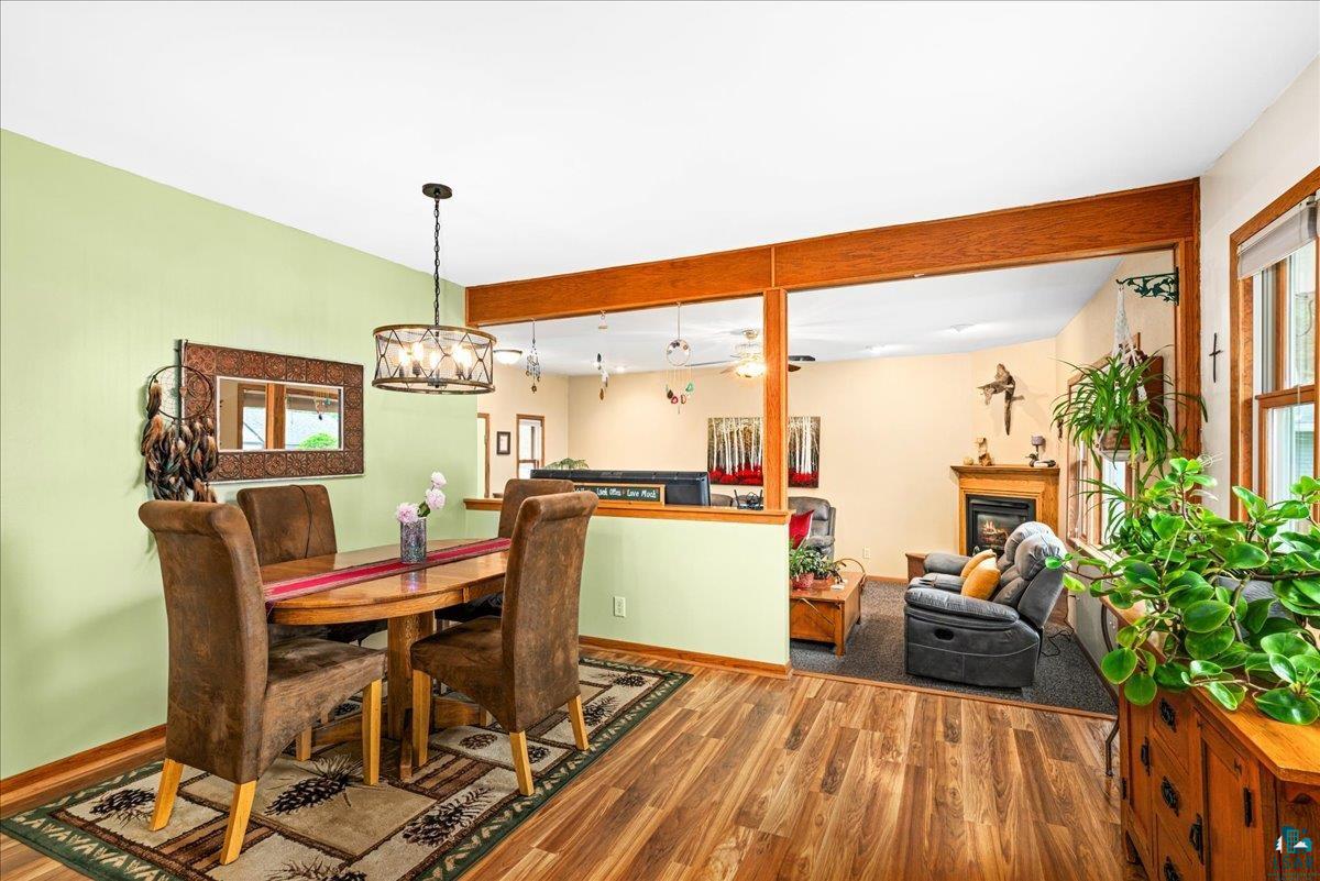 130 West Austin Street Duluth, MN 55803 - Photo 10 of 35 Open-concept dining area featuring wood-finish flooring, a contemporary chandelier, and a wood-trimmed pass-through to the living space