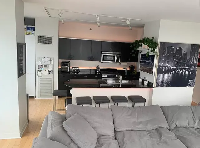 a large white kitchen with stainless steel appliances kitchen island granite countertop a refrigerator and a stove