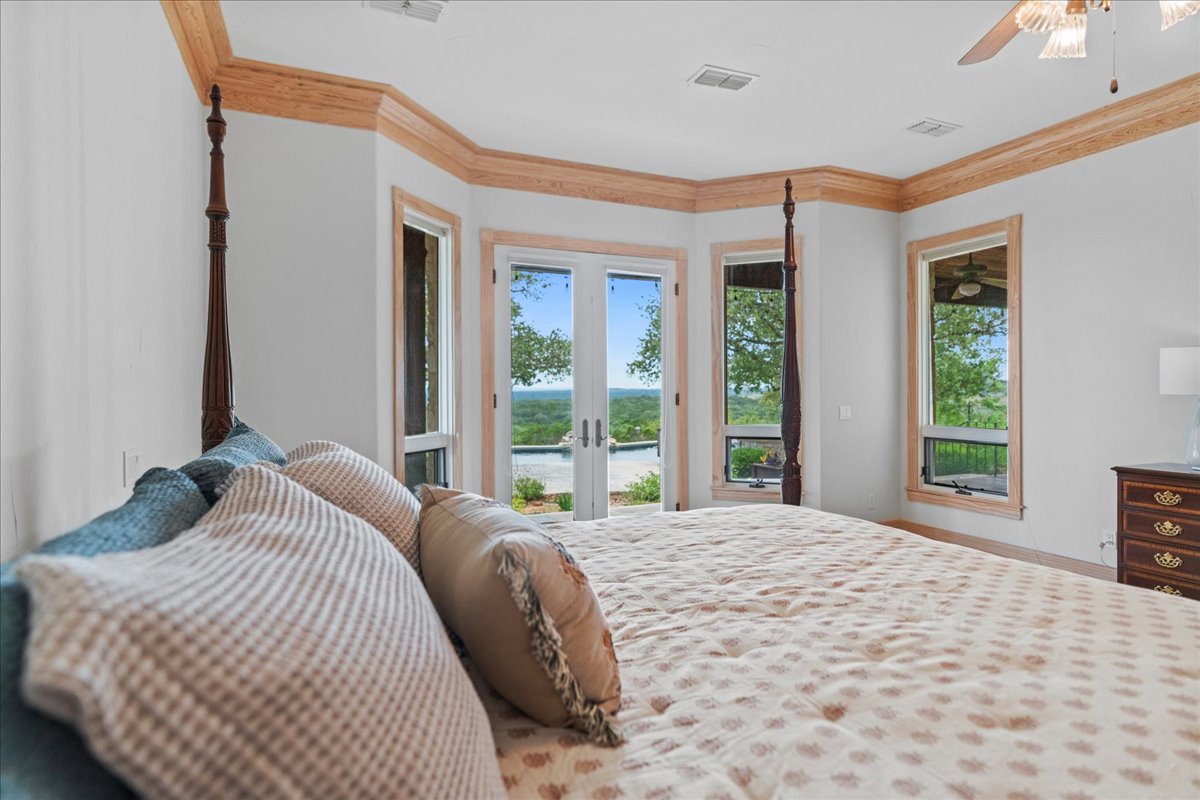 167 Wimberley Ranch Drive Wimberley, TX 78676 - Photo 13 of 40 a bedroom with a large bed and a large window