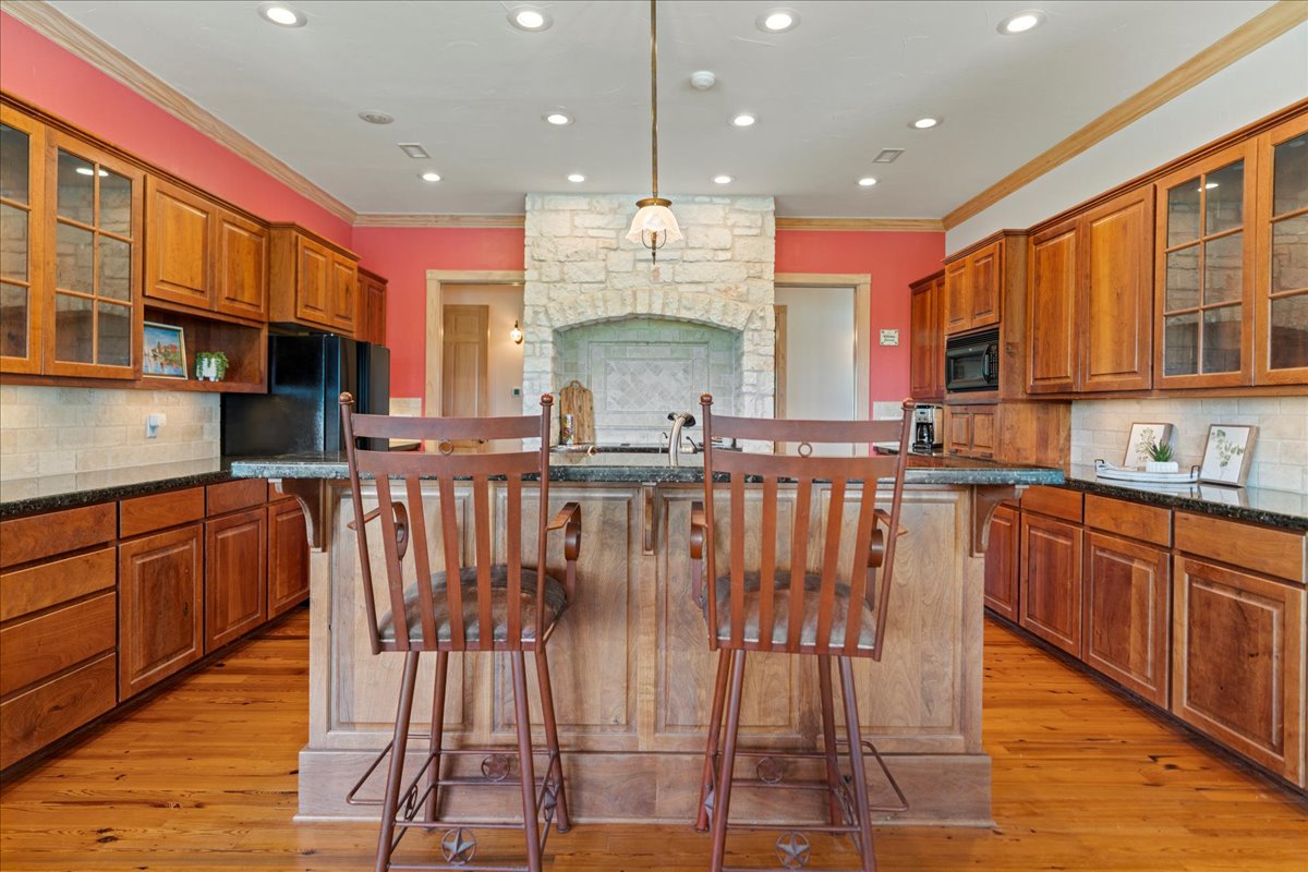 167 Wimberley Ranch Drive Wimberley, TX 78676 - Photo 24 of 40 a kitchen with stainless steel appliances granite countertop a stove top oven a sink dishwasher a dining table and chairs with wooden floor