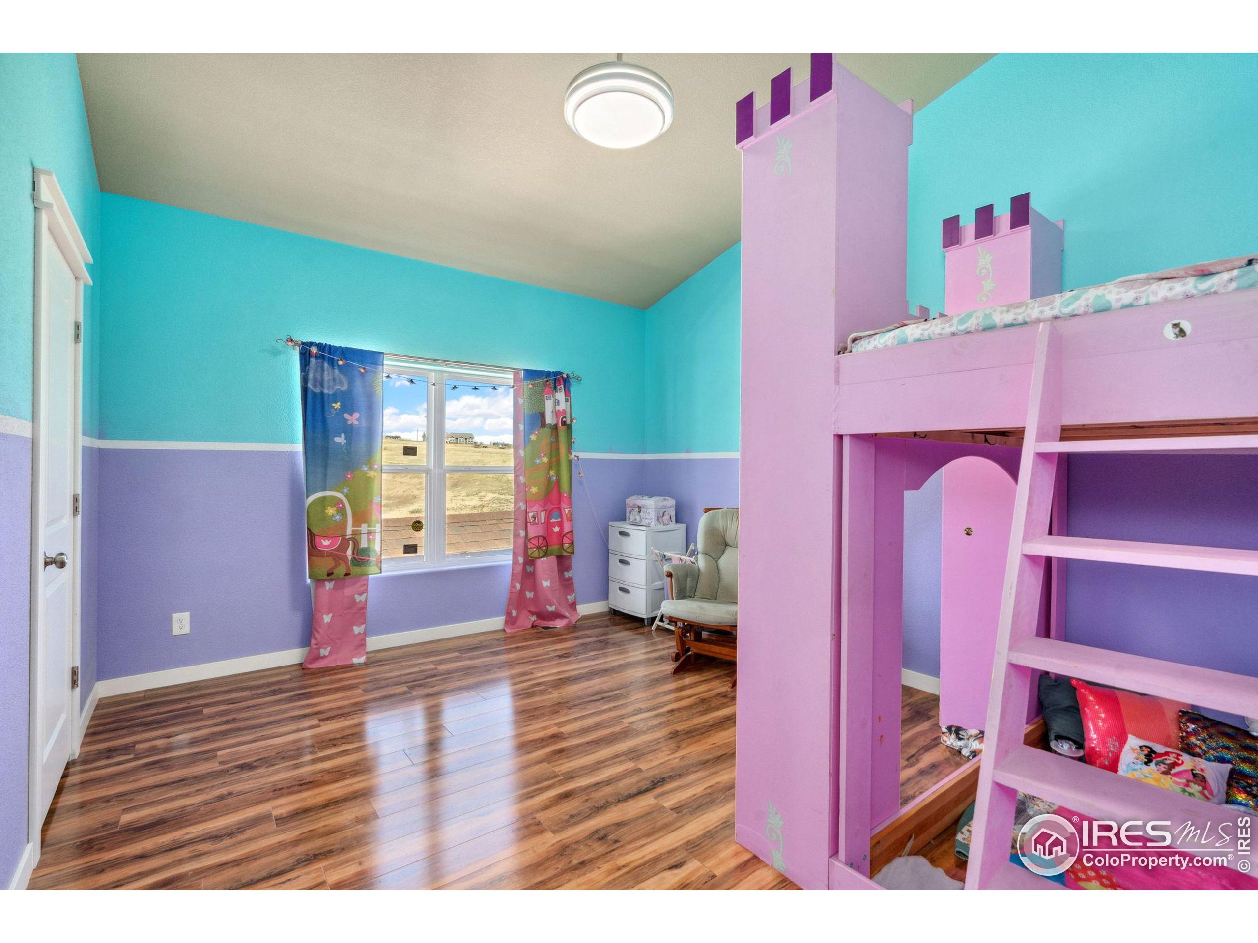 19672 Rawhide Flats Road Wellington, CO 80549 - Photo 20 of 35 a bedroom with a bed and a book shelf