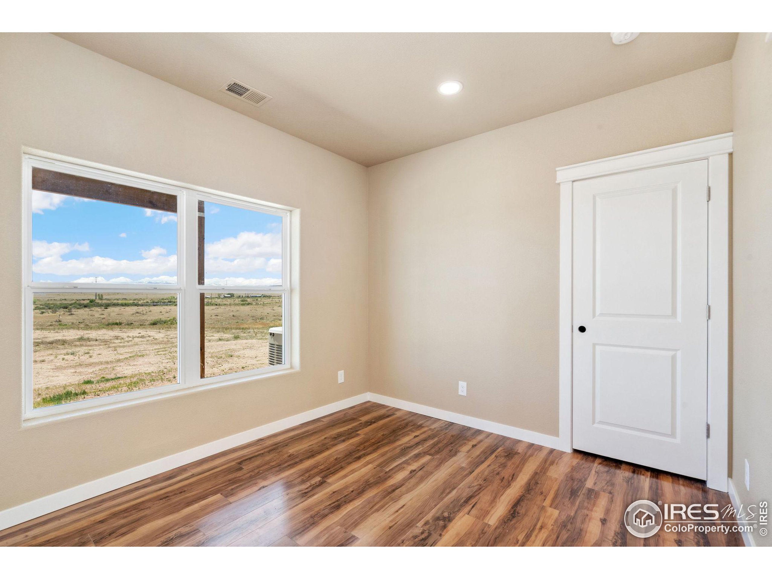 19672 Rawhide Flats Road Wellington, CO 80549 - Photo 26 of 35 a view of an empty room with wooden floor and a window