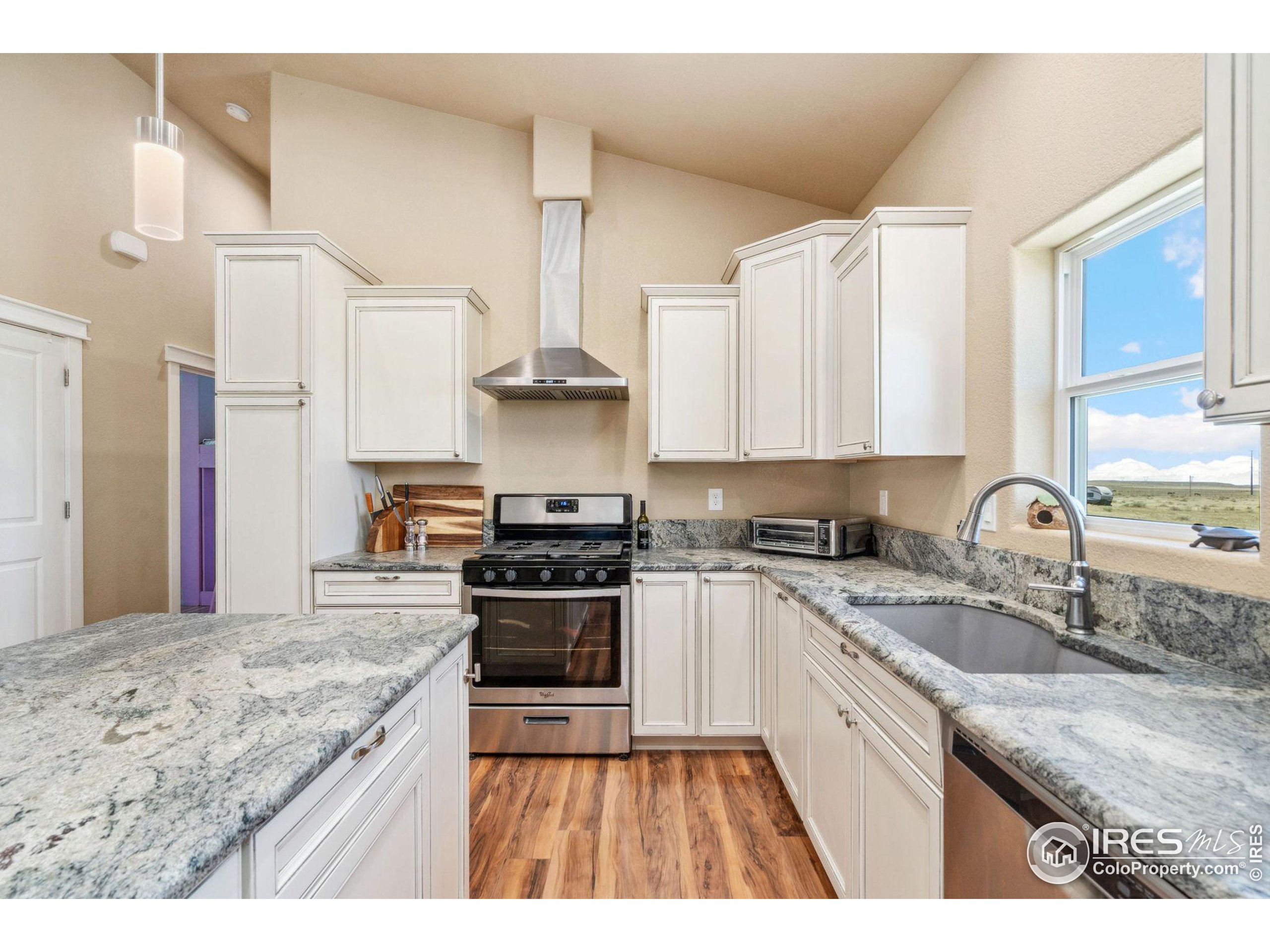 19672 Rawhide Flats Road Wellington, CO 80549 - Photo 6 of 35 a kitchen with stainless steel appliances granite countertop a sink stove and refrigerator