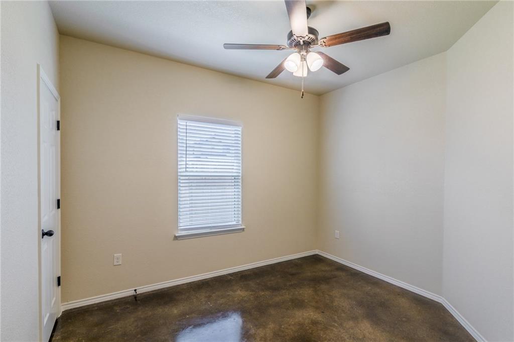 153 Samuel Drive, Unit B Buda, TX 78610 - Photo 18 of 28 an empty room with a chandelier fan and windows