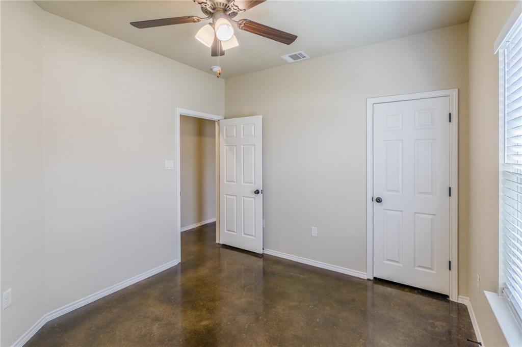 153 Samuel Drive, Unit B Buda, TX 78610 - Photo 2 of 28 an empty room with a ceiling fan and a window